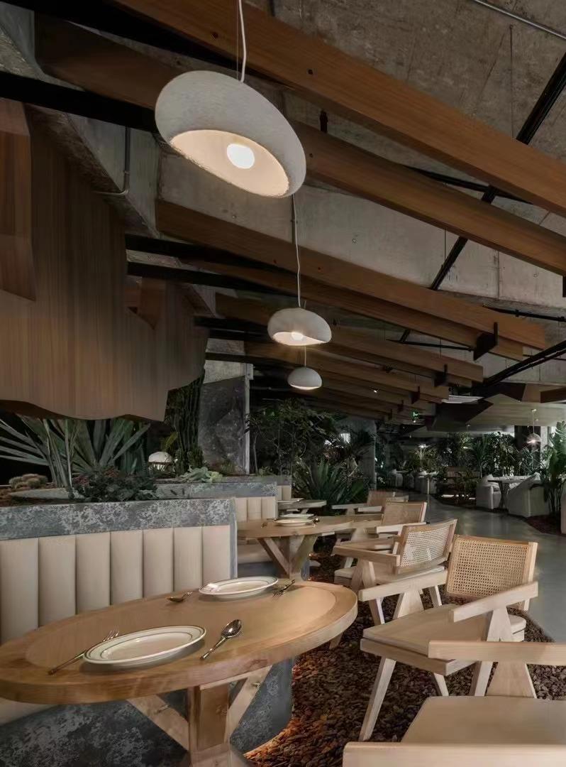 Hospitality dining interior with curved booth seating and warm pendant lights