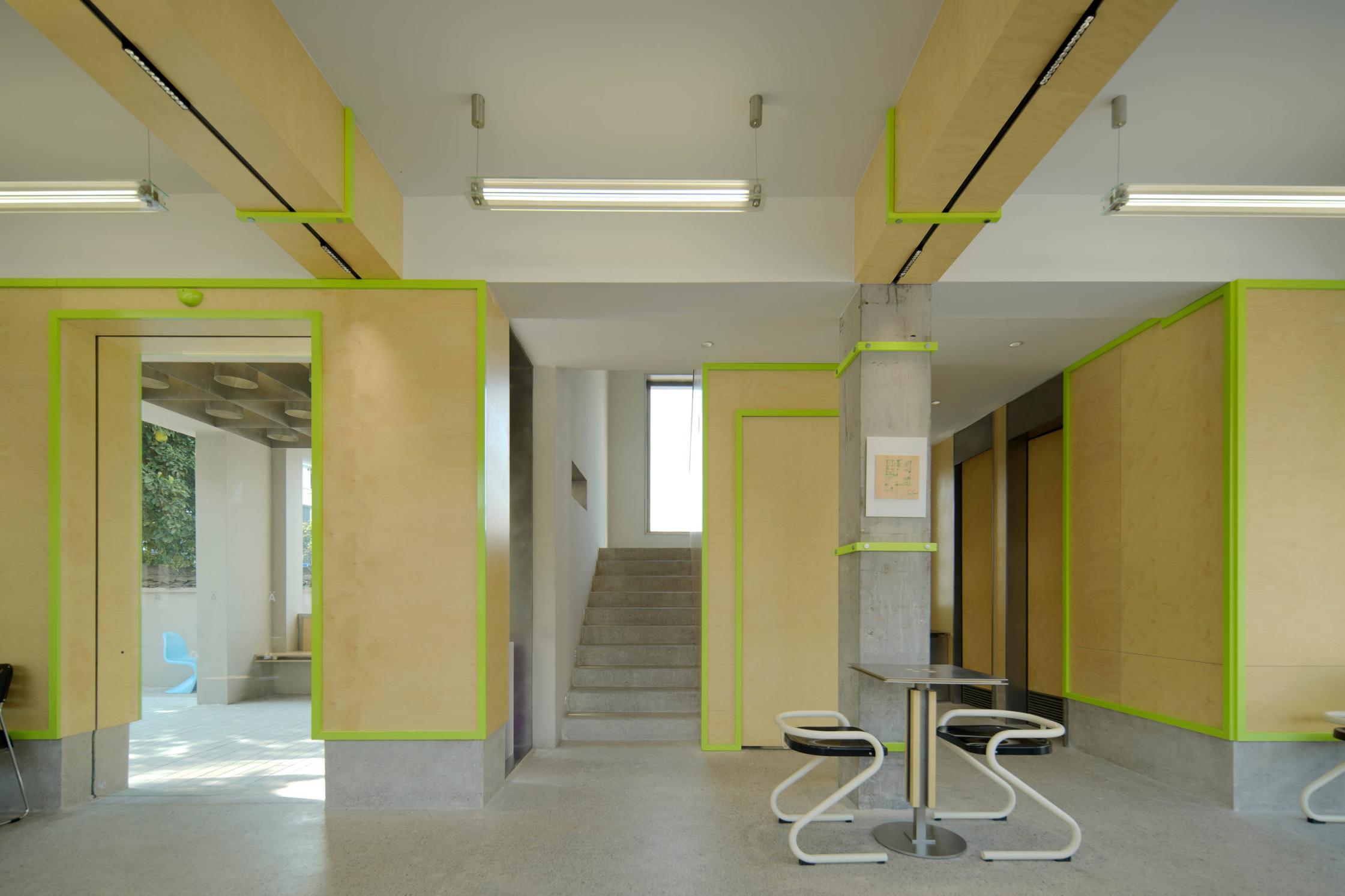Learning space reception counter with green accent lighting and open layout