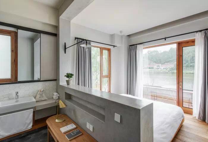 Compact guest room with bed, window and efficient bathroom layout