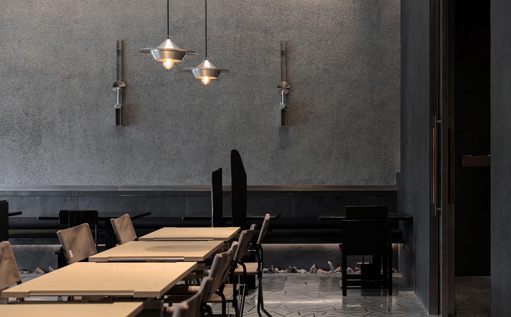 Restaurant dining room with dark textured walls and warm pendant lighting