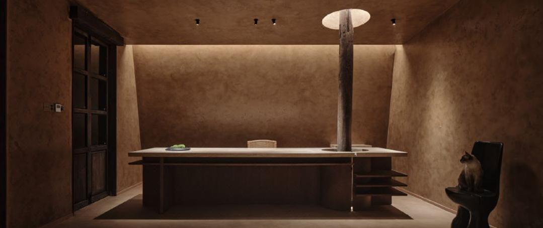 Earth tone resort suite lounge with warm wood ceiling and custom furniture