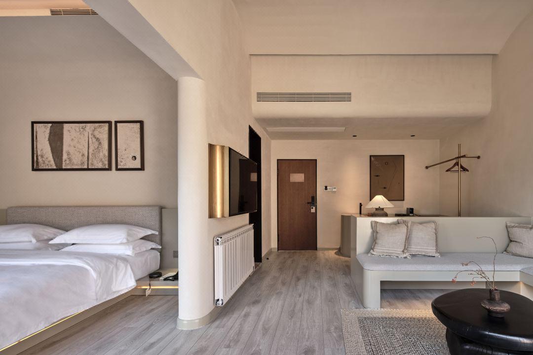 Hotel suite bedroom with built-in furniture and neutral material palette