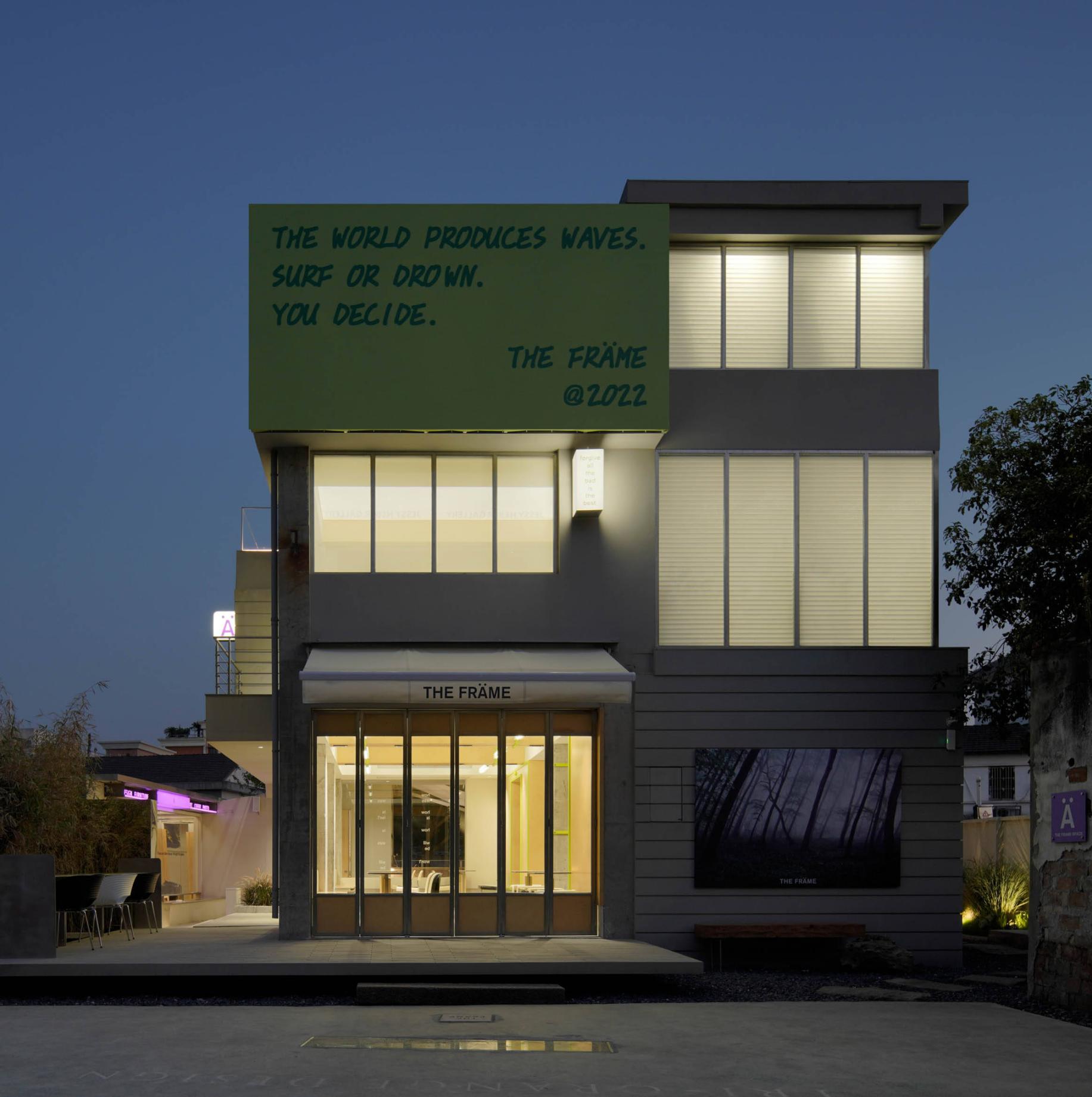 Night view of green commercial showroom with illuminated upper facade