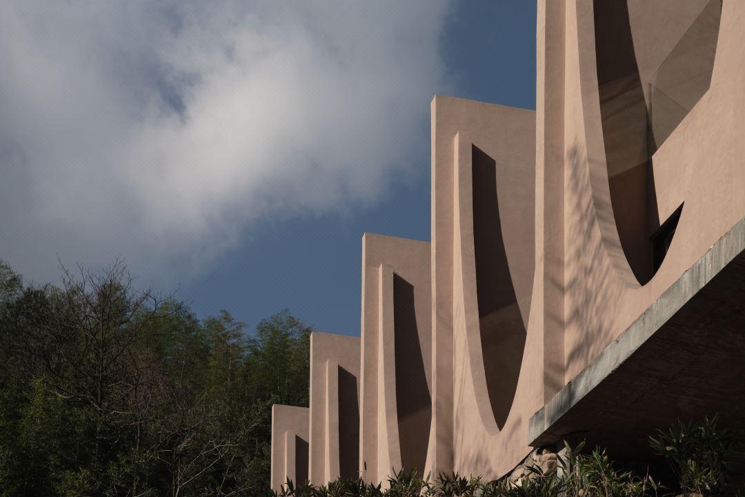 Resort building exterior with sculptural wall forms and natural material palette