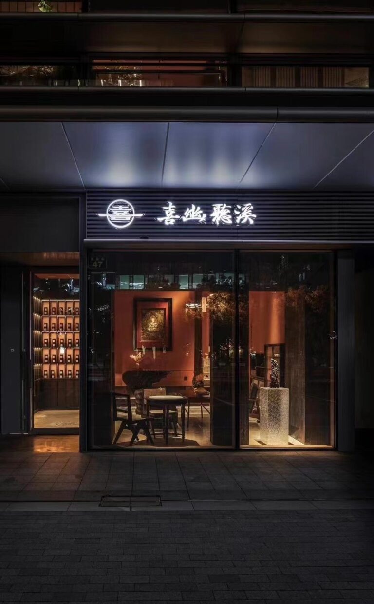 Wine bar street entrance with dark facade and illuminated signage