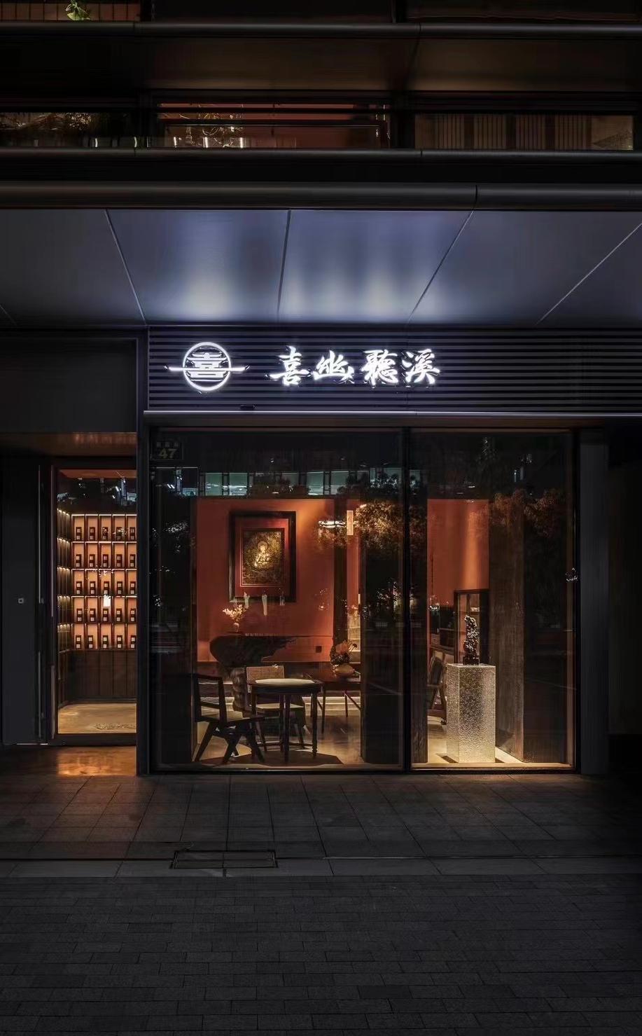 Wine bar street entrance with dark facade and illuminated signage