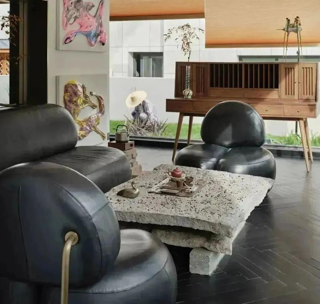 Wine bar lounge seating with art wall and dark leather furniture