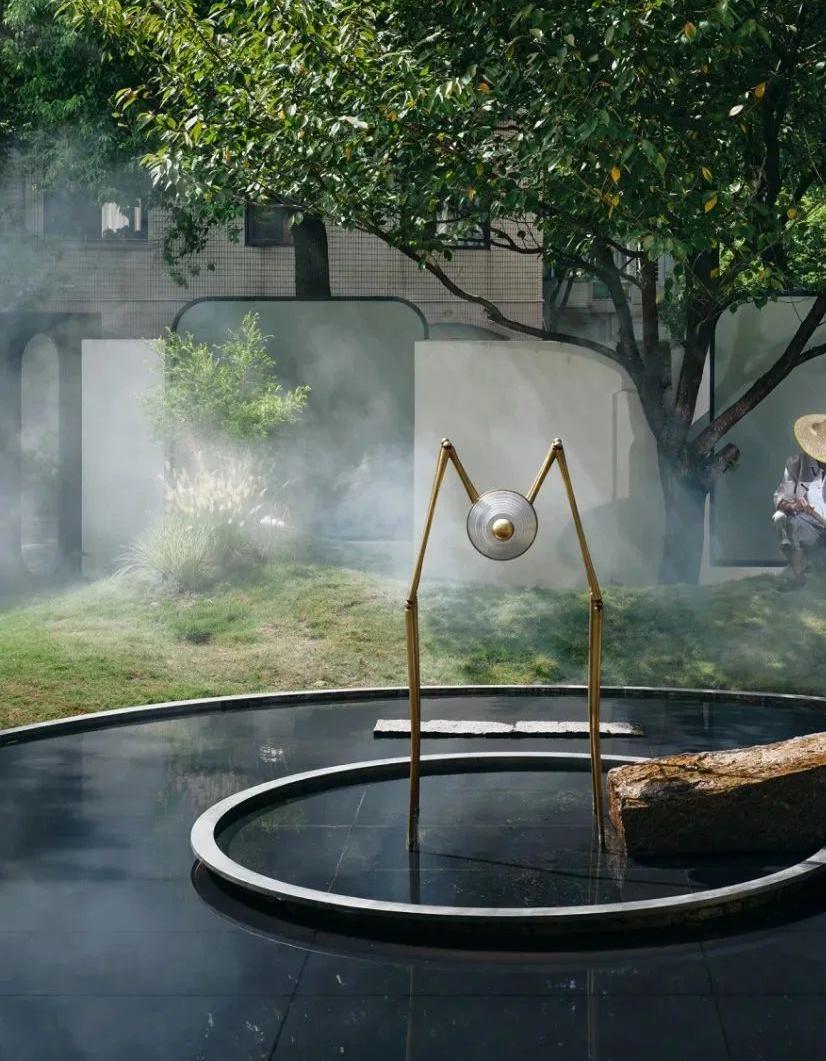 Outdoor lounge feature with circular water element and landscaped seating